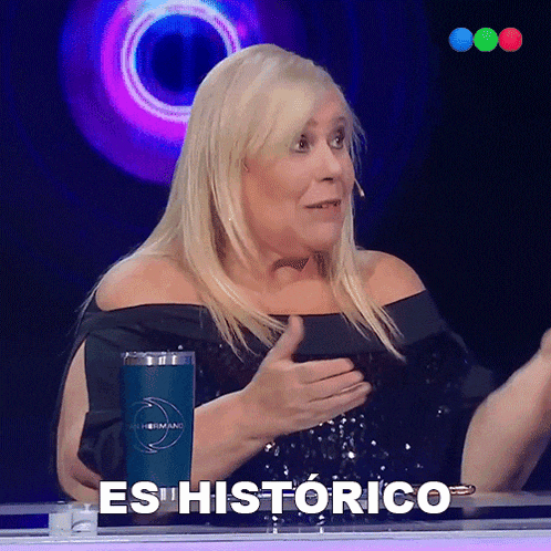 a woman sitting at a table with a cup that says es historico