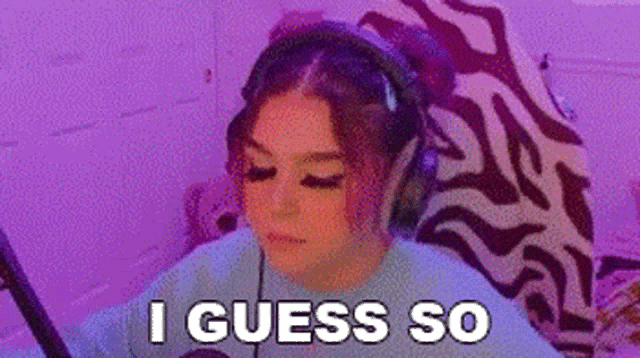 a woman wearing headphones is sitting in front of a computer screen and says `` i guess so '' .