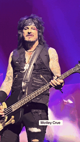 a picture of a man playing a guitar with motley crue in the corner