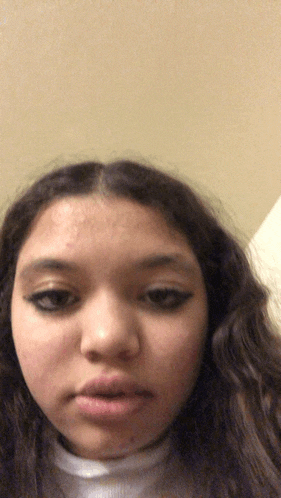 a close up of a girl 's face with a white turtleneck