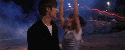 a man is holding a woman in his arms in front of a firework display