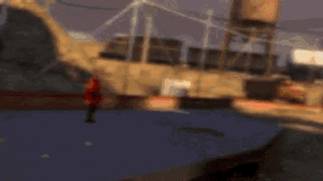 a man in a red jacket is holding a gun in his hand .