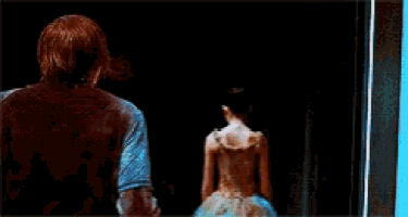 a man and a woman are standing in front of a black curtain .