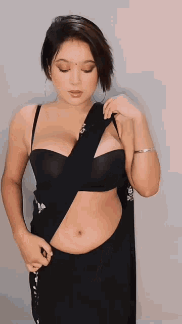 a woman in a black crop top giving a peace sign
