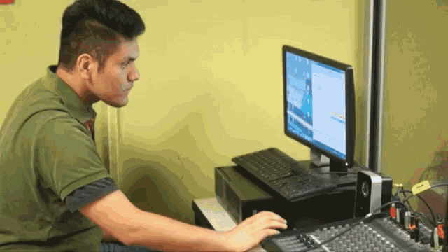 a man sitting at a desk with a dell computer on it