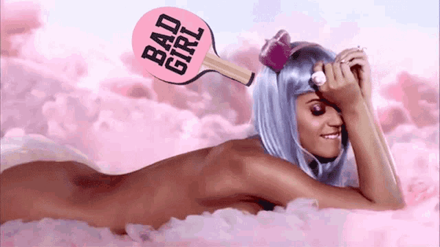 a naked woman is laying on a cloud with a bad girl paddle