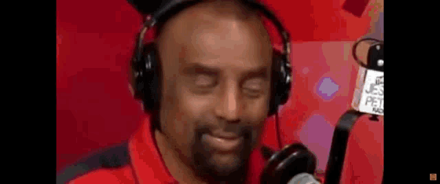 a man wearing headphones is talking into a microphone .