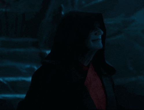 a man in a black robe with a hood and red eyes