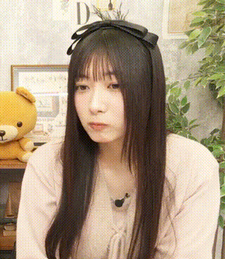 the girl is wearing a headband with a bow on it and a teddy bear is behind her .