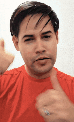 a man is wearing a red shirt and giving a thumbs up
