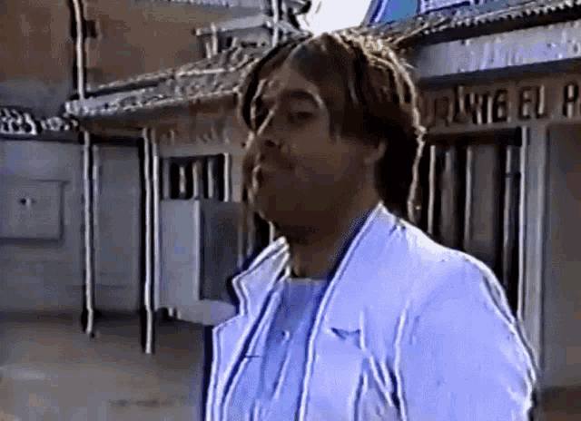 a man in a white coat is standing in front of a building that says ponte eu