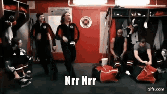 a group of hockey players in a locker room with nrr nrr written on the screen