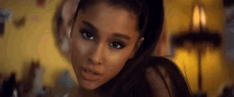 a close up of a woman 's face with her hair in a ponytail .