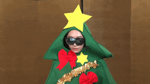 a person dressed in a christmas tree costume with a star on top