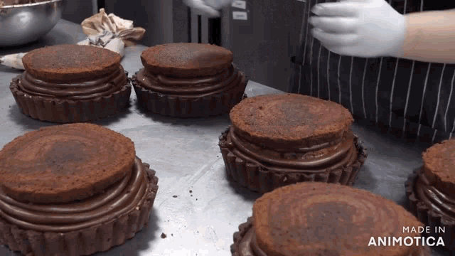 a bunch of chocolate cupcakes on a table with the words made in animatica on the bottom right