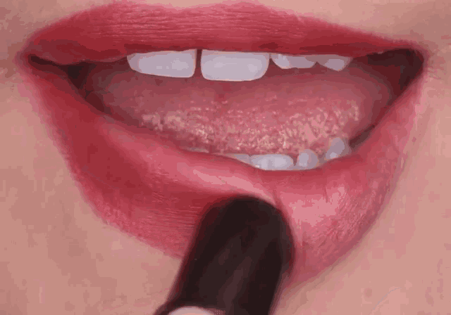 a woman applying red lipstick to her lips