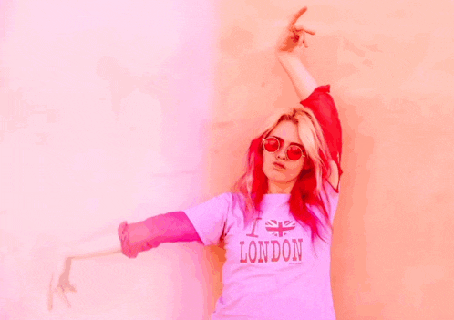 a woman with red hair is wearing a pink london shirt