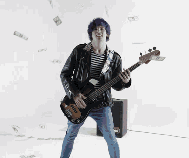 a man with purple hair is playing a bass guitar with money falling around him