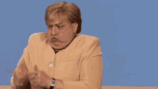 a woman in a tan jacket is pointing her finger at something