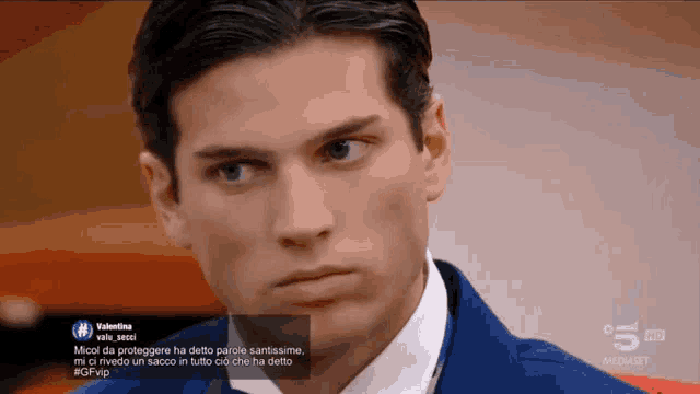 a man in a suit and tie is looking at the camera with a tweet from valentina