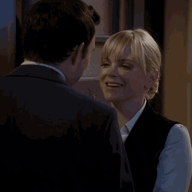 a man and a woman are looking at each other and the woman is smiling