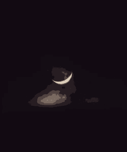 a crescent moon in a dark sky with clouds
