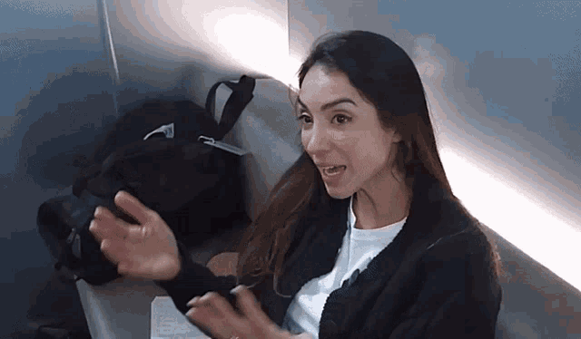 a woman in a black sweater is sitting on a chair