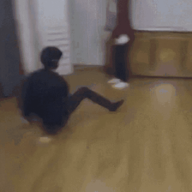 a blurry picture of a person standing on their knees on a wooden floor