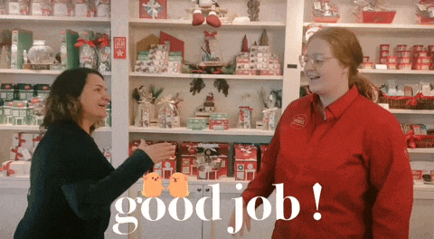 a woman in a red jacket says good job to another woman in a store