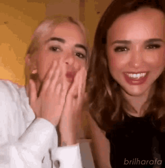 a couple of women are standing next to each other and smiling .