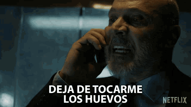 a man talking on a cell phone with the words deja de tocarme los huevos written below him