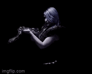 a woman with purple hair is holding a snake in her hands .