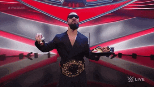 a wrestler is holding a tray of food in front of a wwe live sign