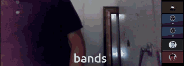 a man in a purple shirt stands in front of a wall with the word bands written on it