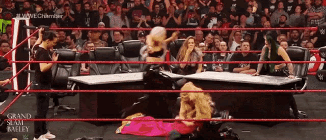 a woman in a pink dress is in a wrestling ring with the words grand slam bailey on the screen