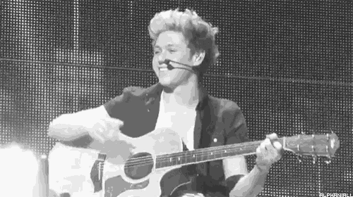 a man is playing an acoustic guitar in front of a microphone .