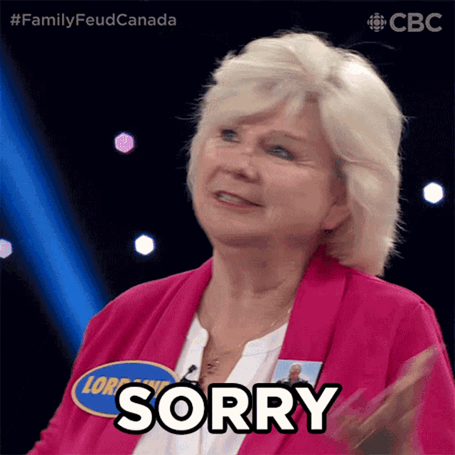 a woman in a pink jacket says sorry on a stage