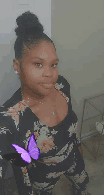 a woman taking a selfie with a purple butterfly next to her