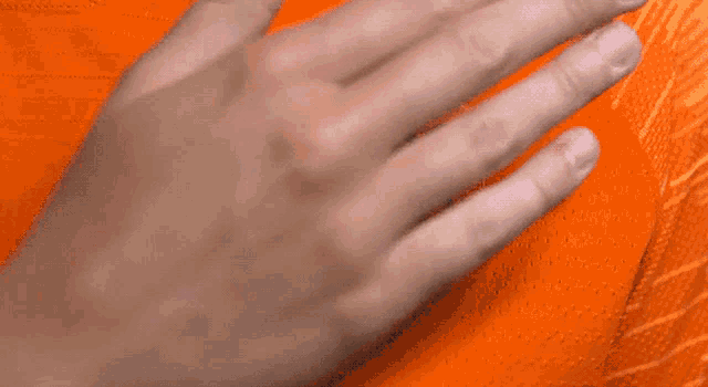 a close up of a hand on an orange background