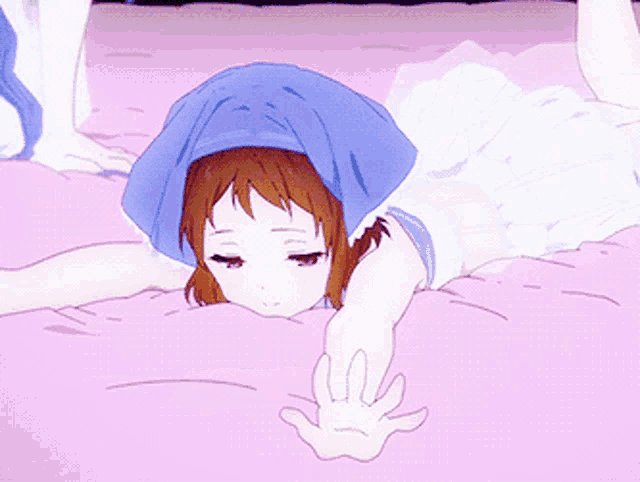 a girl is laying on a bed with her eyes closed and a blue towel on her head