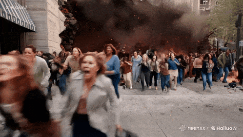 a crowd of people running in front of a building that is being destroyed by a fire