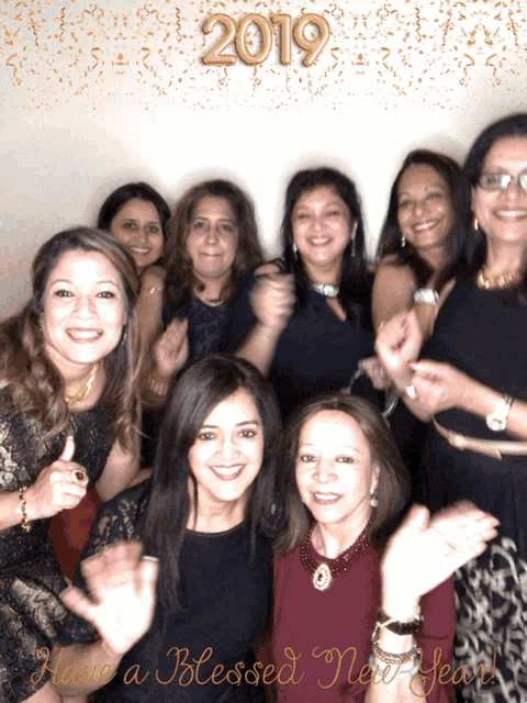 a group of women are posing for a picture with the year 2019 in the background