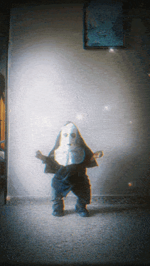 a child in a nun costume stands in front of a wall with a picture on it