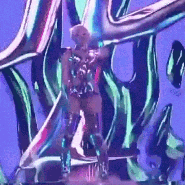 a woman is dancing on a stage in front of a purple background