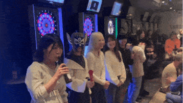 a group of people are standing in front of a dart board with a sign that says throw