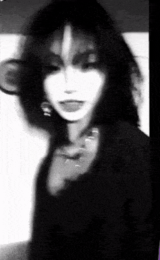 a black and white photo of a woman 's face with a blurred background .