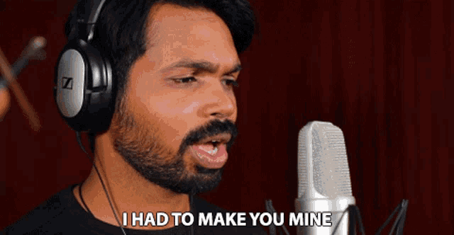 a man wearing headphones singing into a microphone with the words " i had to make you mine " below him