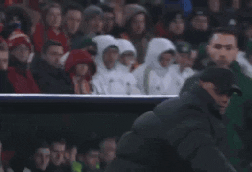 a man kicking a soccer ball on a field with a cooler in the background