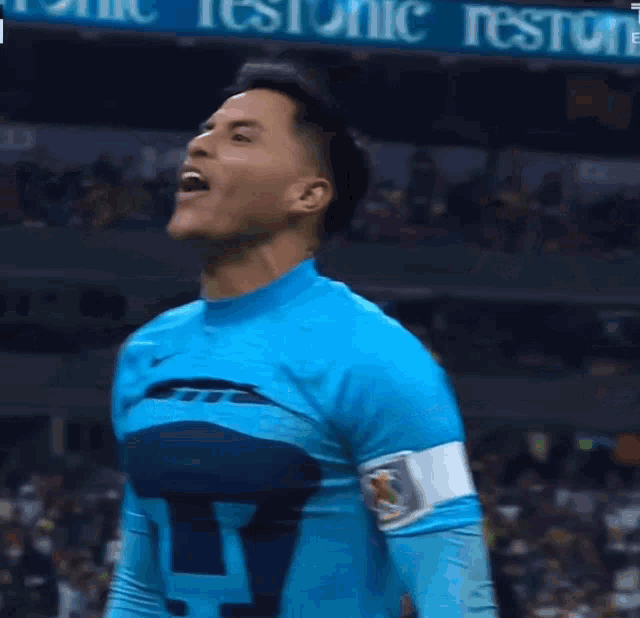 a man wearing a blue pumas jersey is laughing