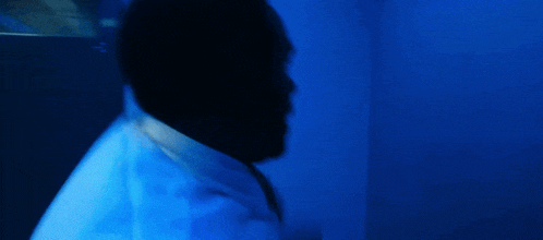 a blurry picture of a person in a bathroom with a blue light